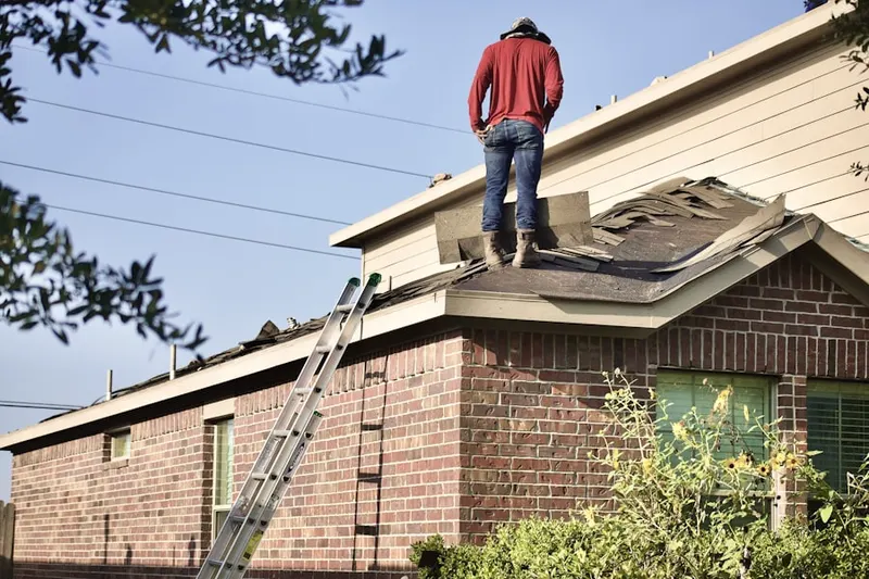 Professional roofer working on a residential roof in Bellair